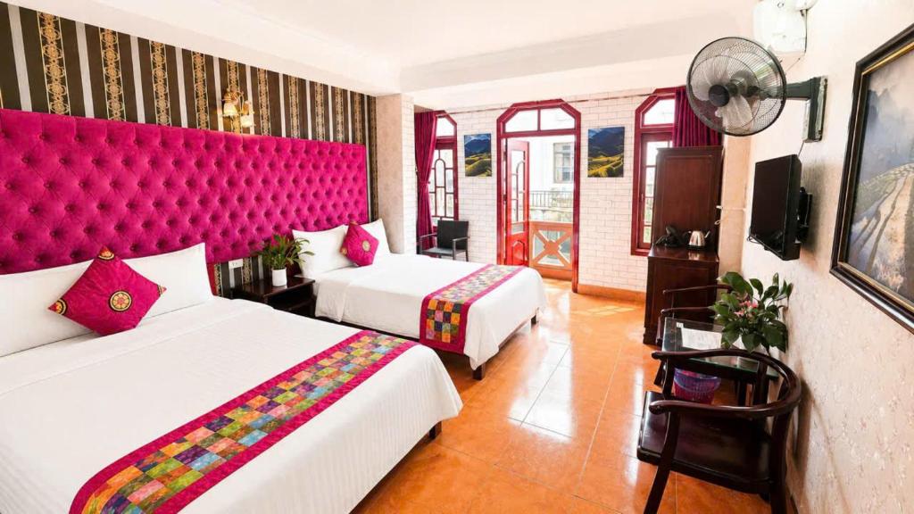 a hotel room with two beds and a red headboard at Hà Giang Hotel Sapa in Sapa