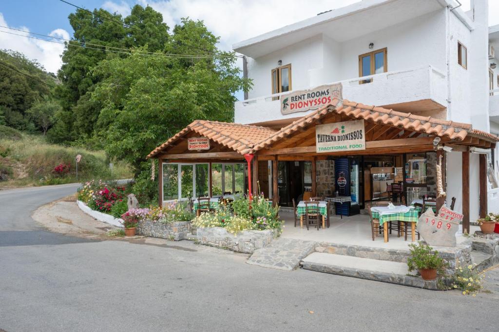 a store front of a building with tables and chairs at Dionysus House in Magoulás