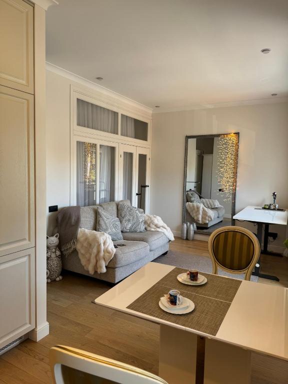 a living room with a couch and a table at Sunny Central Apartment on Central Square in Daugavpils
