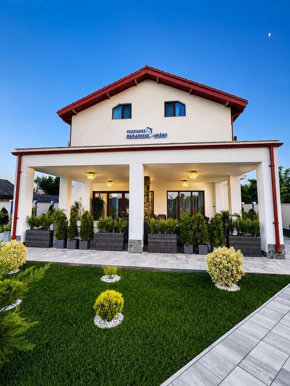 a large white building with a green yard at Pensiunea Paradisul Mării in Sulina