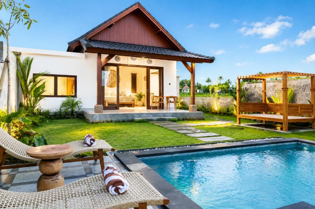 a villa with a swimming pool and a house at Bagus Bandem Villa in Ubud