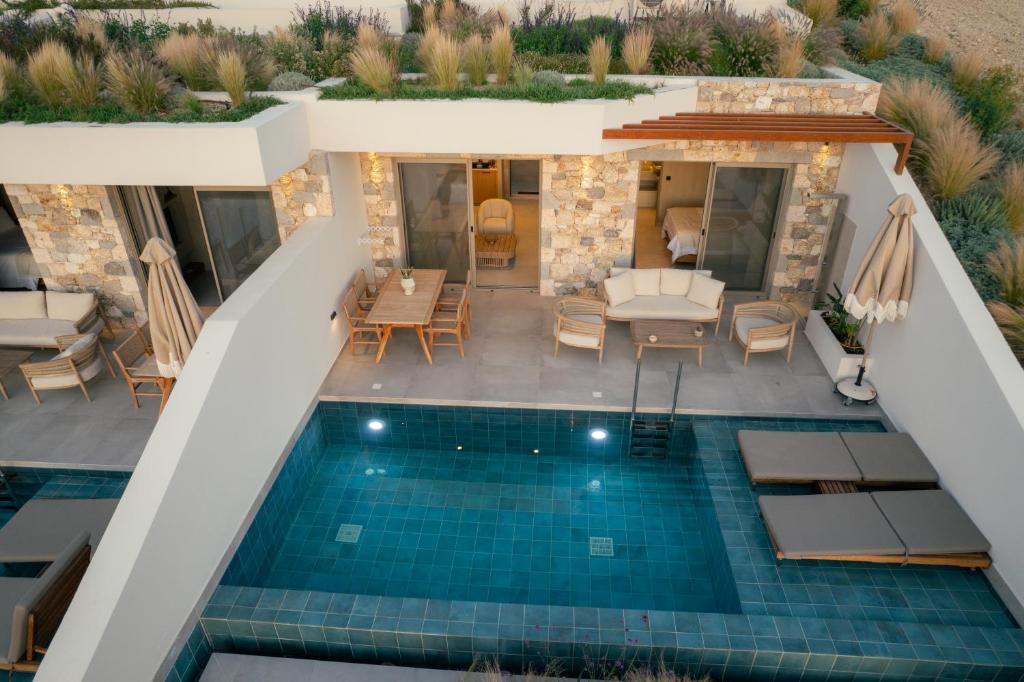an overhead view of a swimming pool with chairs and a house at Akres Luxury Sea View Villas in Psalidi