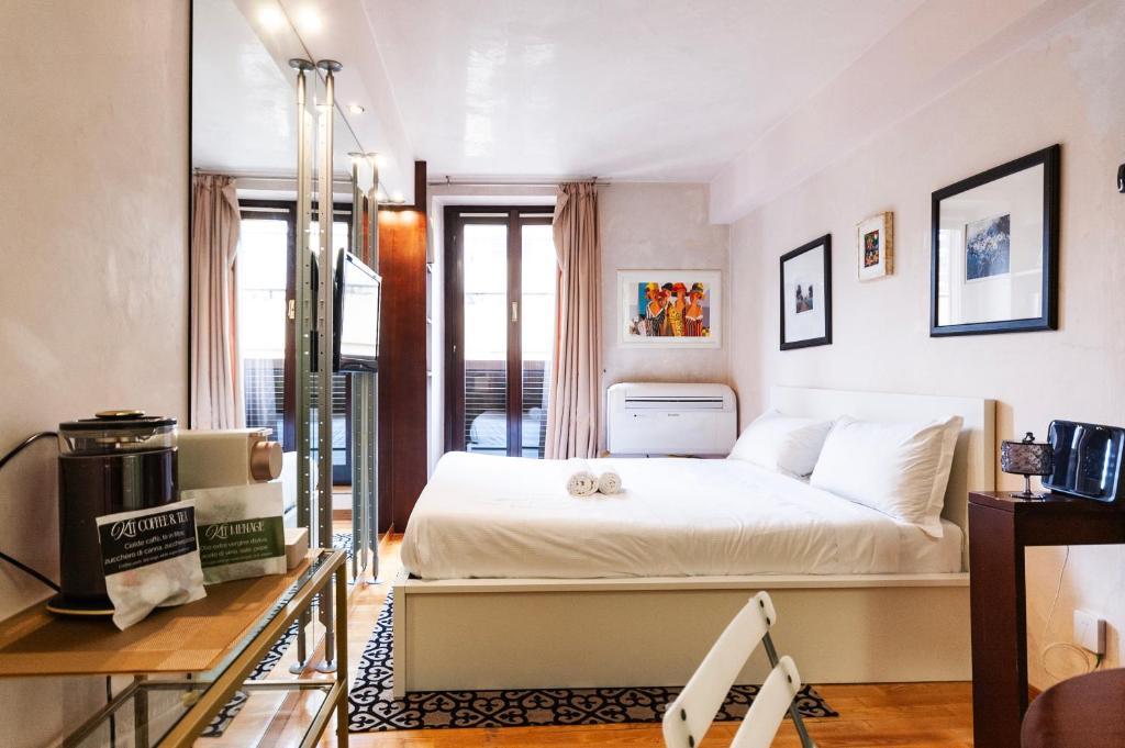 a small bedroom with a bed and a balcony at Youhosty - Duomo Studio Apartment in Milan