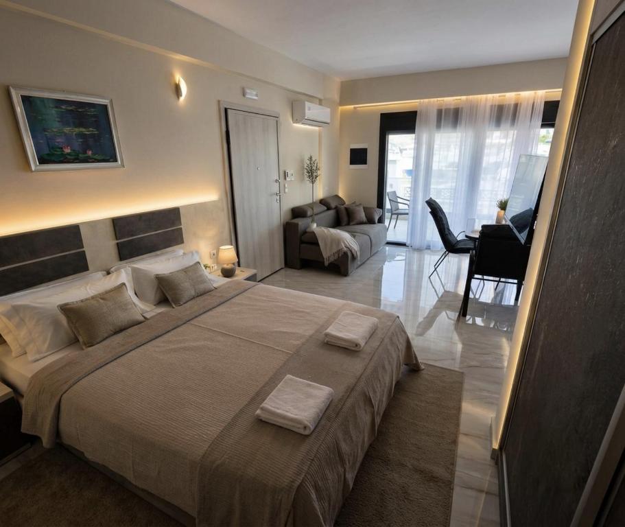 a bedroom with a large bed and a living room at Marine Apartment in Nea Peramos