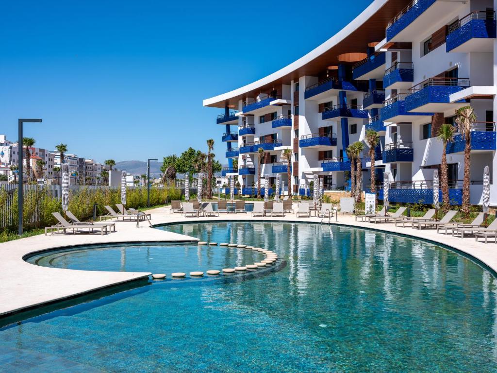 a swimming pool in front of a building at Zephyr Martil in Martil