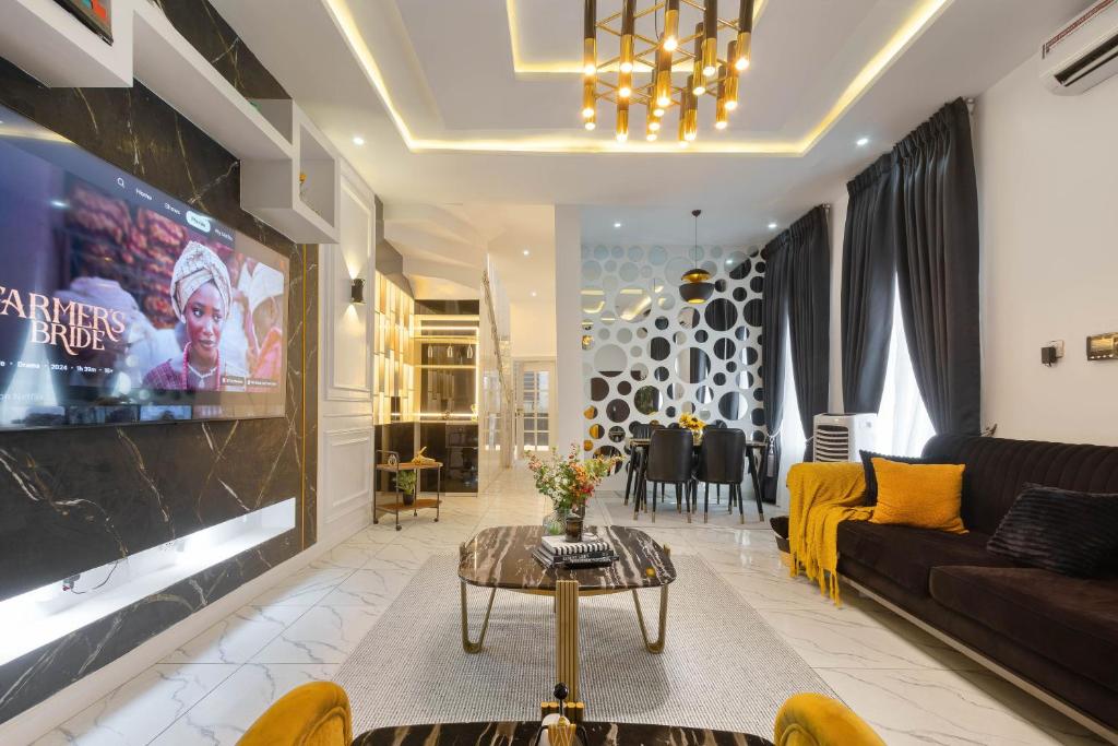 a living room with a couch and a tv at Modern 3BR Smart Villa near Lekki Conservation with Inverter PS5, Hot Tub and Gym in Ibeju