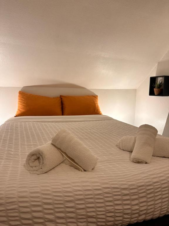 a white bed with towels on top of it at Le Studio du Square : Châteaux-Beauval-Arrivée auto-Netflix in Romorantin
