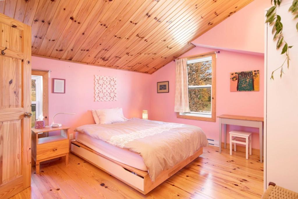 a bedroom with a bed and a wooden ceiling at La Reine in St-Etienne de Bolton