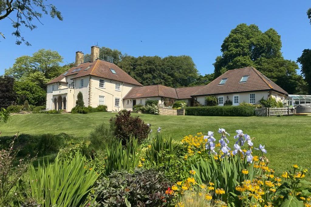 a house on a hill with a garden and flowers at 1 Bed in Clatcombe oc-s33309 in Castletown