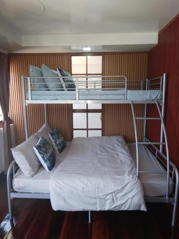 two bunk beds in a room with a white bed at Felrita Homestay in Alegria