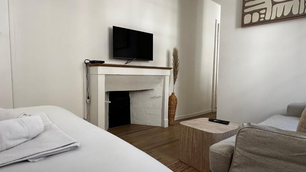 a living room with a tv on a fireplace at Le Fabuleux - 2 Guests in Dijon