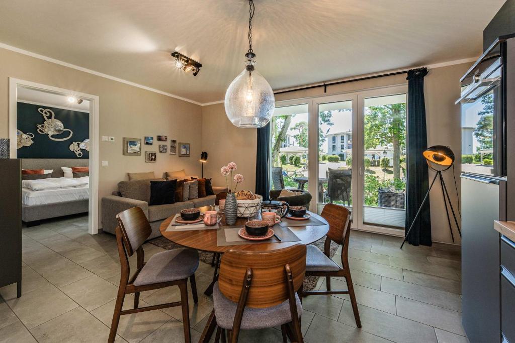 a dining room and living room with a table and chairs at Terrasse am Haff in Zirchow