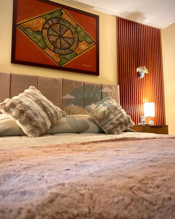 a bed with two pillows on top of it at Cabaña entre Bosques in Concepción