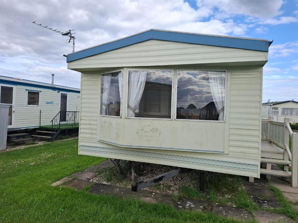 a small house with a window in a yard at Atlas Florida in Ingoldmells
