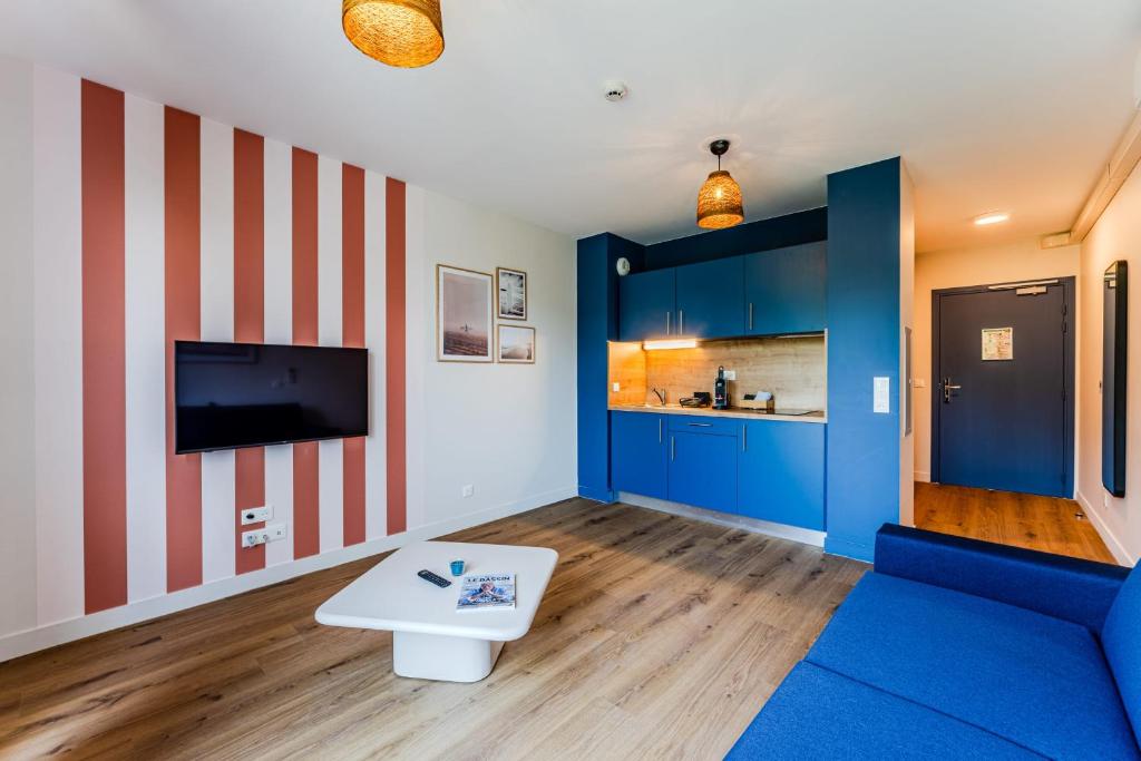 a living room with a blue couch and a tv at Studio for 2 in La Teste-de-Buch parking in La Teste-de-Buch