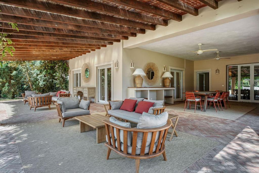 a patio with a couch and chairs and a table at Casa das Cegonhas in Vale de guiso