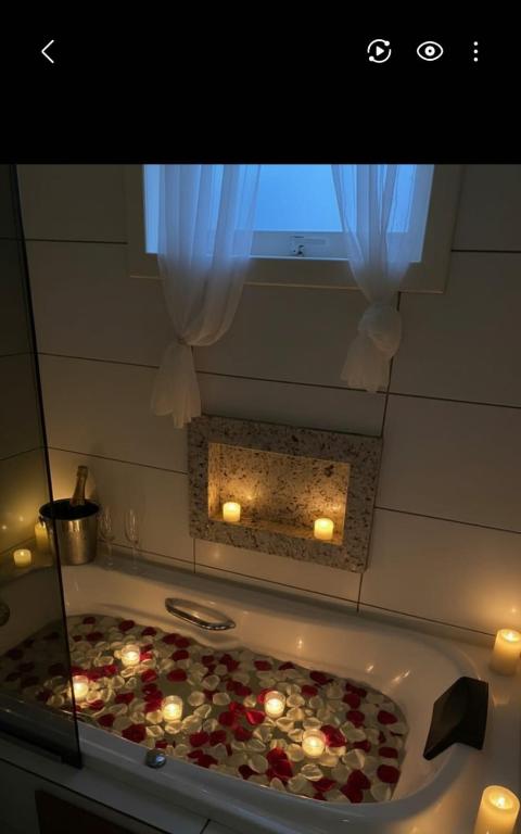 a room with a bath tub with candles in it at Chalé Vale Carahá Hortensia in Gramado
