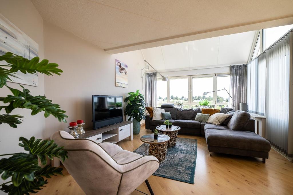 a living room with a couch and a tv at Penthouse Ostrea 60 in Nes