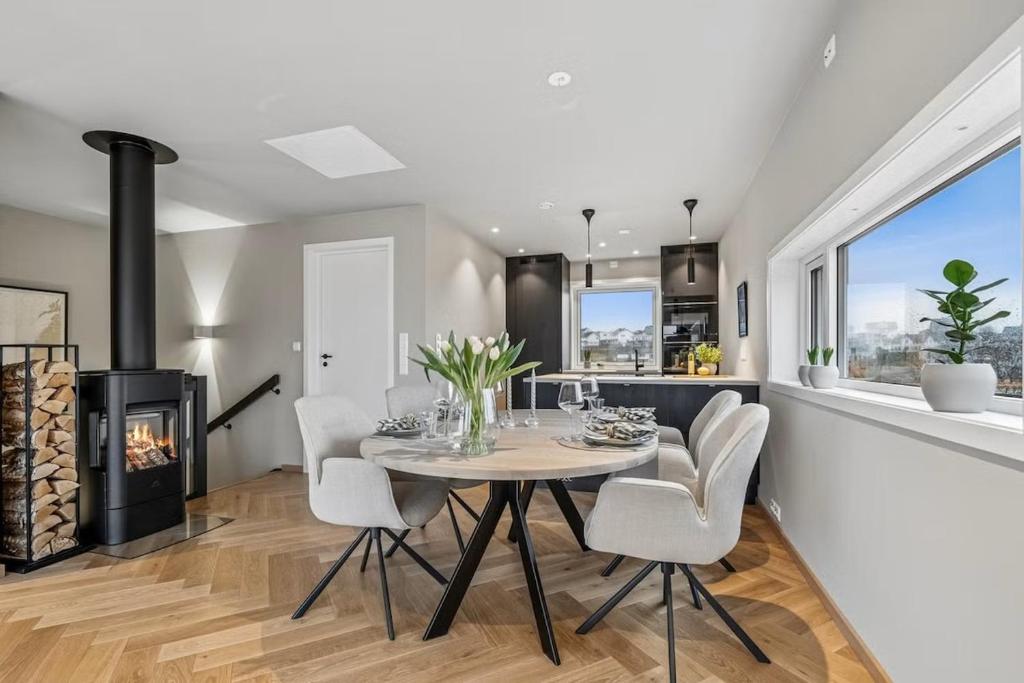 a dining room with a table and a fireplace at Apartment Lofoten, Leknes in Leknes