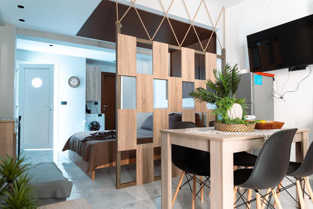 a living room with a dining table and a bedroom at Village Bliss in Kardamaina