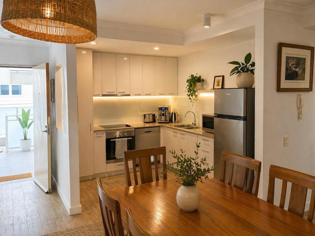 a kitchen and dining room with a table and a refrigerator at Sundown terrace in North Fremantle