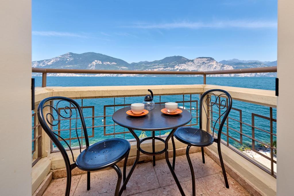 a table and chairs on a balcony with the ocean at The Lake Balcony by Gardenjoy in Brenzone sul Garda