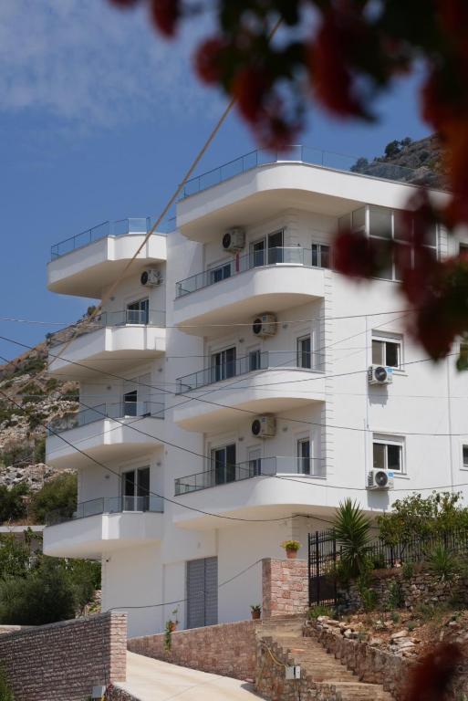 a white building with balconies on a hill at Villa Er Deti in Sarandë