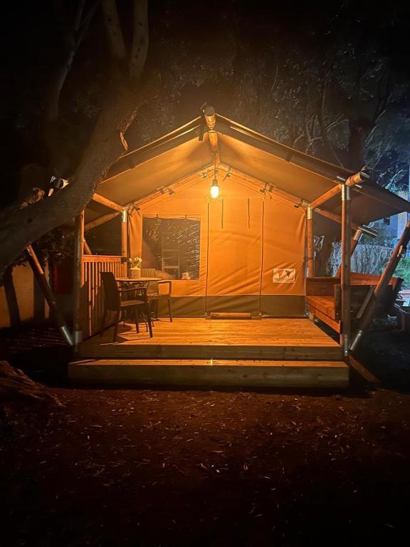 a tent with a table in the middle at night at GLAMPING by SUNBEAM in Leporano Marina