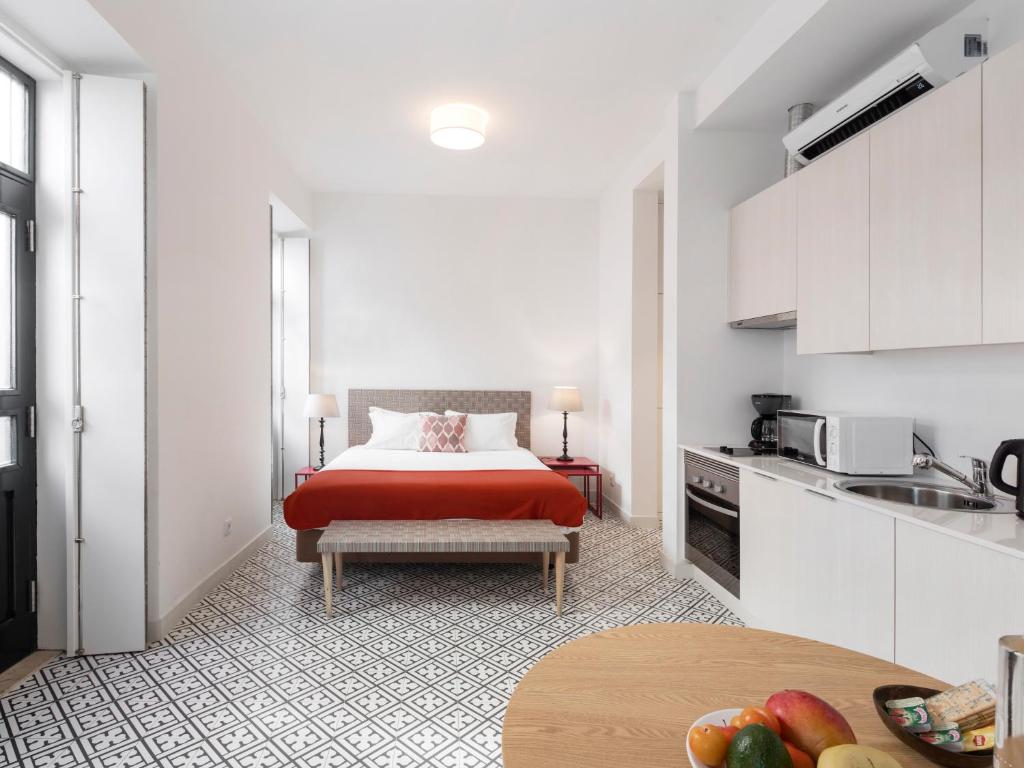 a bedroom with a red bed and a kitchen at LSA Castelo S Jorge by Numa in Lisbon