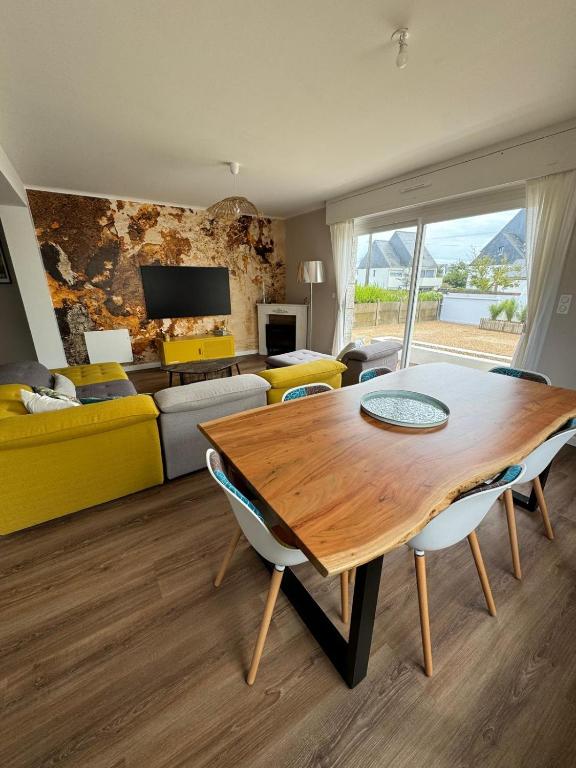 a living room with a wooden table and chairs at Maison proche centre ville in Quiberon