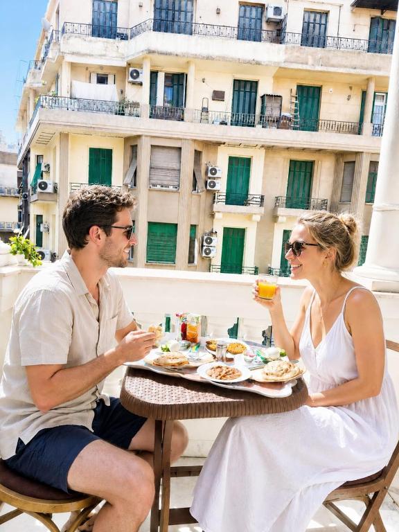 a man and woman sitting at a table eating food at New palace court in Cairo