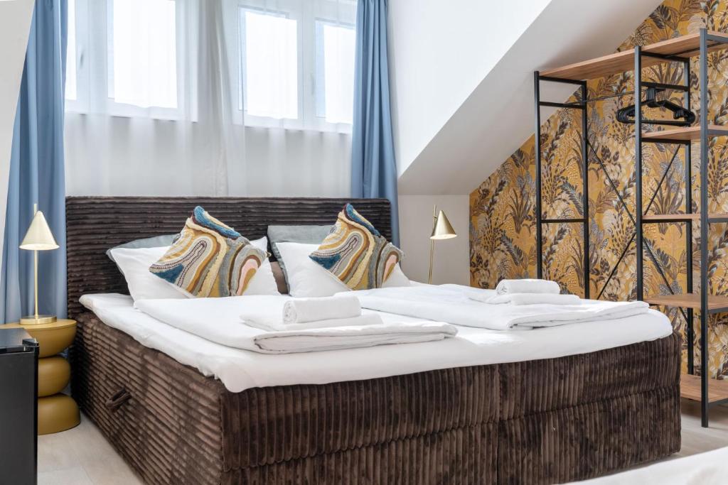 a bedroom with a large bed with white sheets and pillows at Villa Vaicun - Boutique Rooms in Lörrach