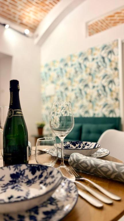 a table with plates and a wine glass on it at UrbanSuite Torino in Turin