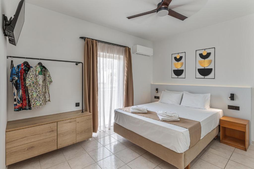 a bedroom with a bed and a ceiling fan at Sunny Vibes by Estia Adults Only in Stalís