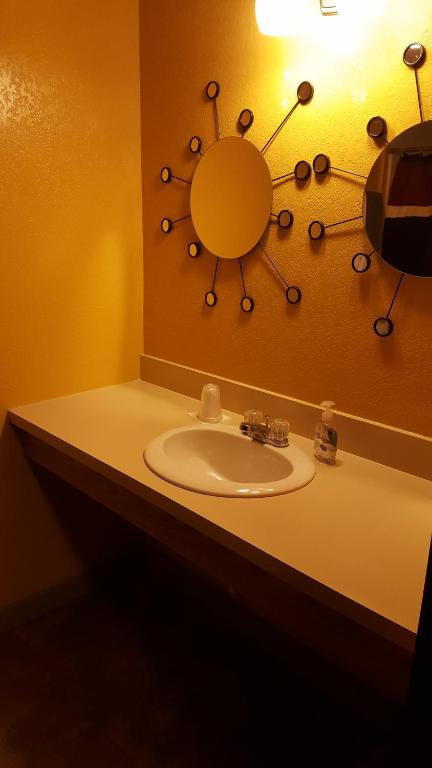a bathroom with a sink and a mirror at Earth Inn Motel - Jackson in Jackson