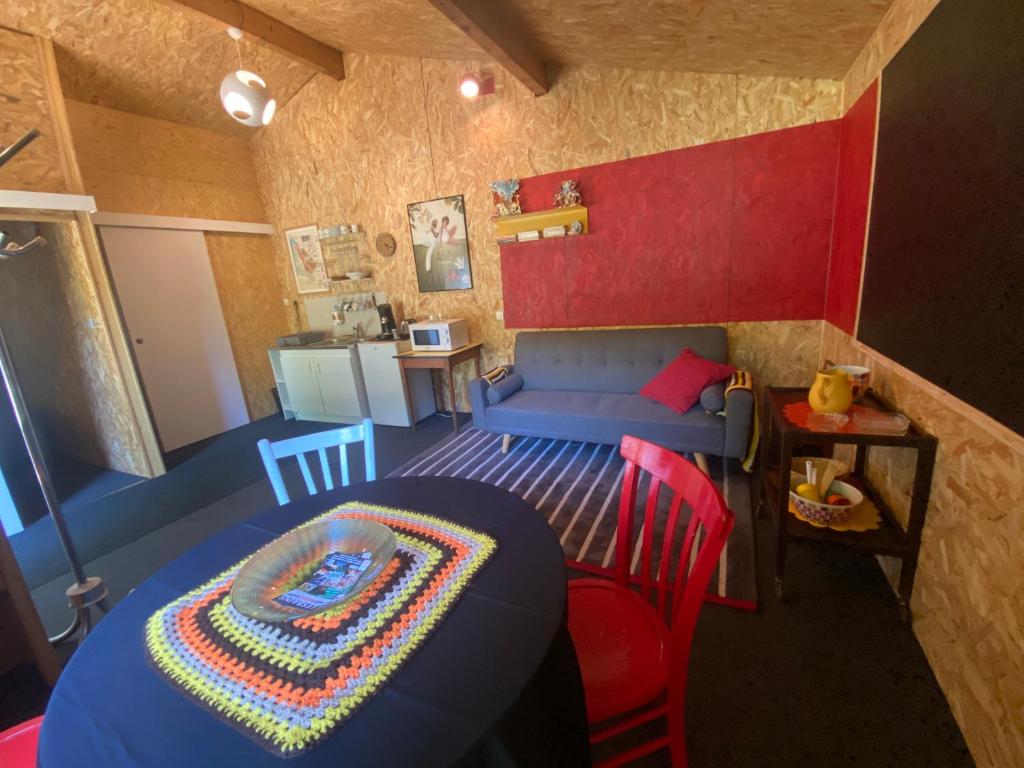 a small room with a blue table and a couch at La Cabane des Bains in Marciac
