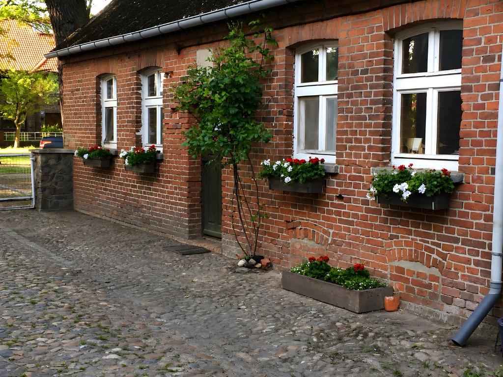a brick house with flowerpots on the side of it at Jagdstube in Prezelle