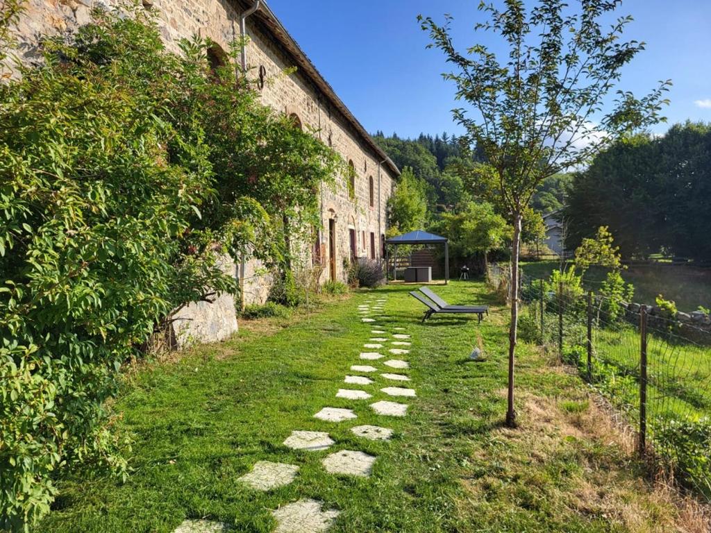 a stone path in front of a building with a bench at La Bastide d'Amalthée in Vernay