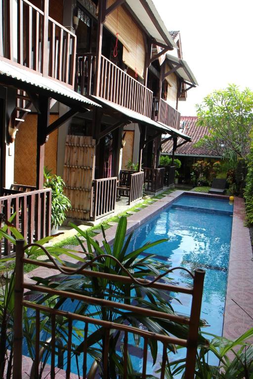 un complejo con piscina frente a un edificio en Venezia Homestay and Garden en Yogyakarta