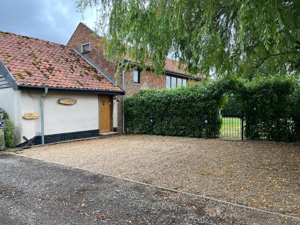 a house with a driveway in front of a fence at Old Field Barn Luxury B&B in Attleborough