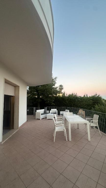 a patio with a table and chairs and a boat at Li Geusi in Torre Lapillo