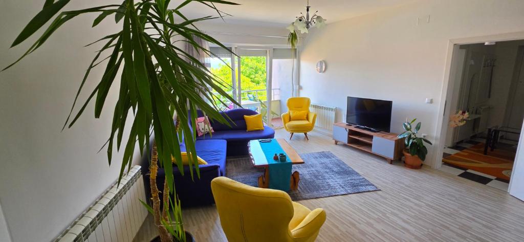 a living room with a blue couch and yellow chairs at Struga Alpha House in Struga