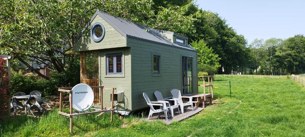a green tiny house with a table and chairs at Tiny House Climatisée Bernières in Bernières