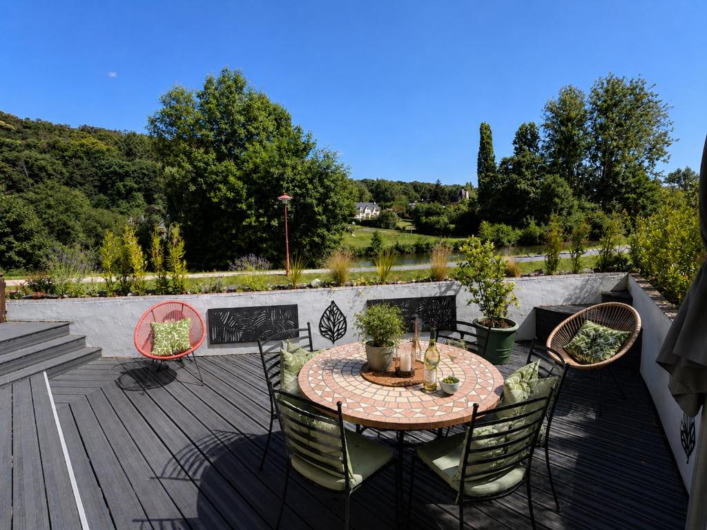 a patio with a table and chairs on a deck at Quai du Val is a Charming Pet and Family Friendly Riverside Gite in Lehon close to Dinan Sleeps 7 in Dinan