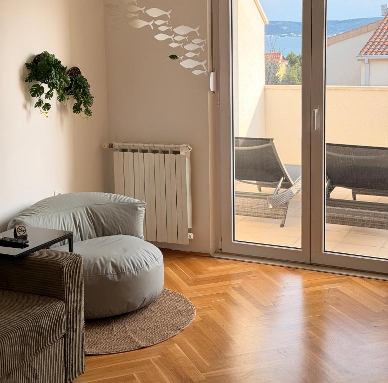 a living room with a chair and a ottoman at TIMO Apartment Split Croatia in Kaštela