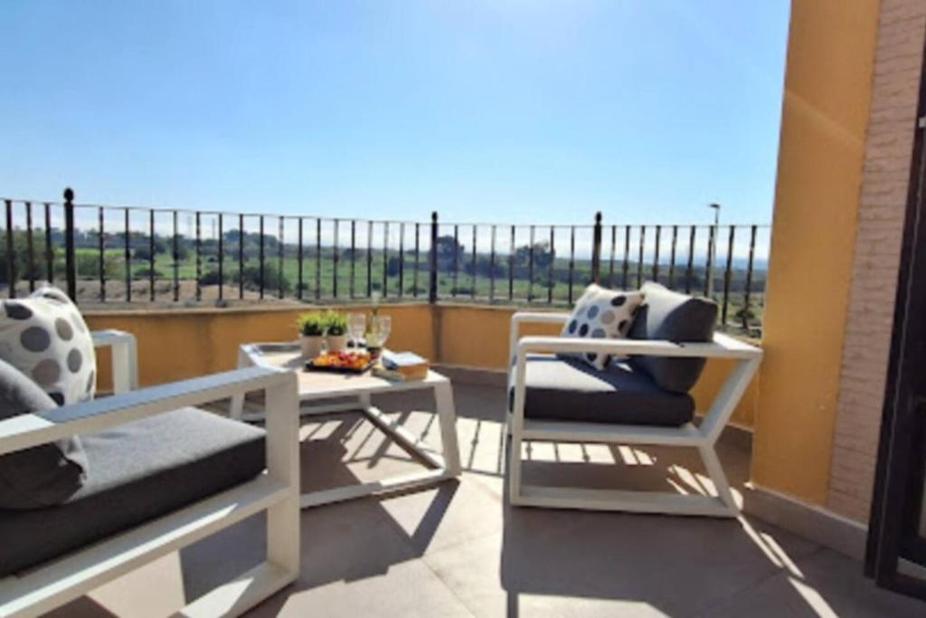a balcony with two chairs and a table with a view at Salona Geus in Algorfa