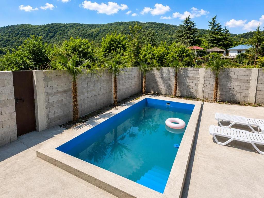 a swimming pool on a patio next to a fence at Mountain breeze in Lagodekhi