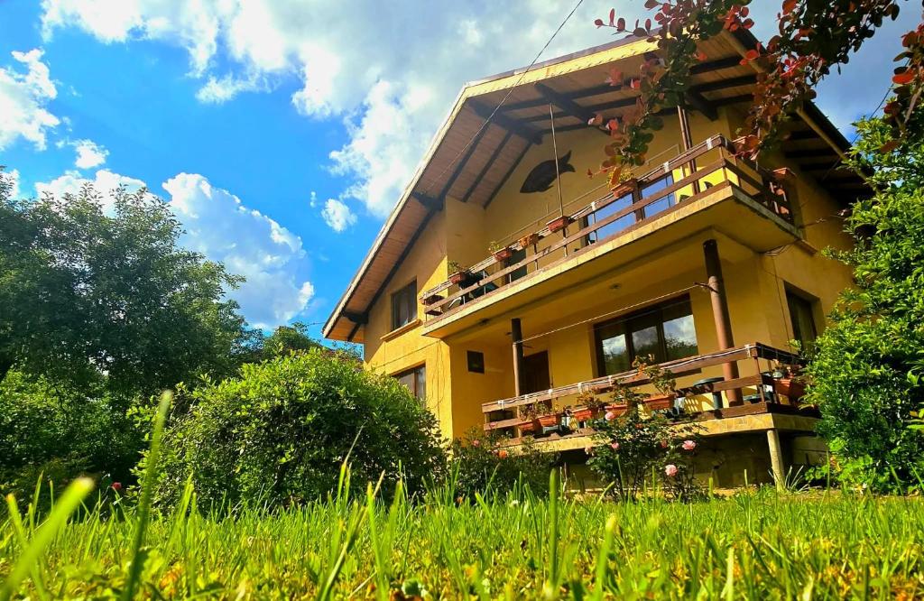 a yellow house with plants on the balcony at Villa Ribarica in Ribarica