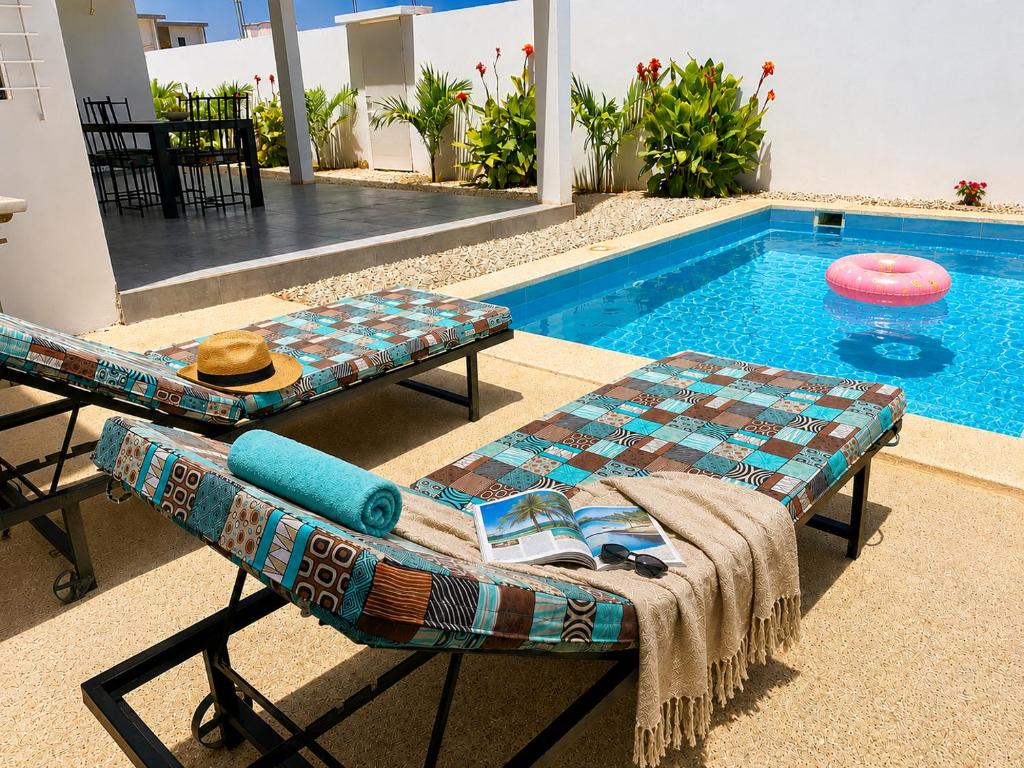a pool with a bench and a table and a frisbee at Les Hirondelles in Ngaparou