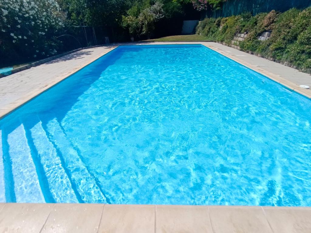 a swimming pool with blue water in a yard at T2 duplex + piscine avec parking in Montpellier